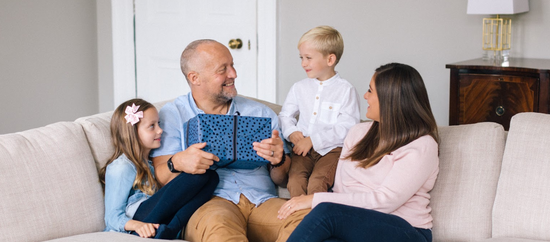 Family celebrating dad's birthday on the sofa